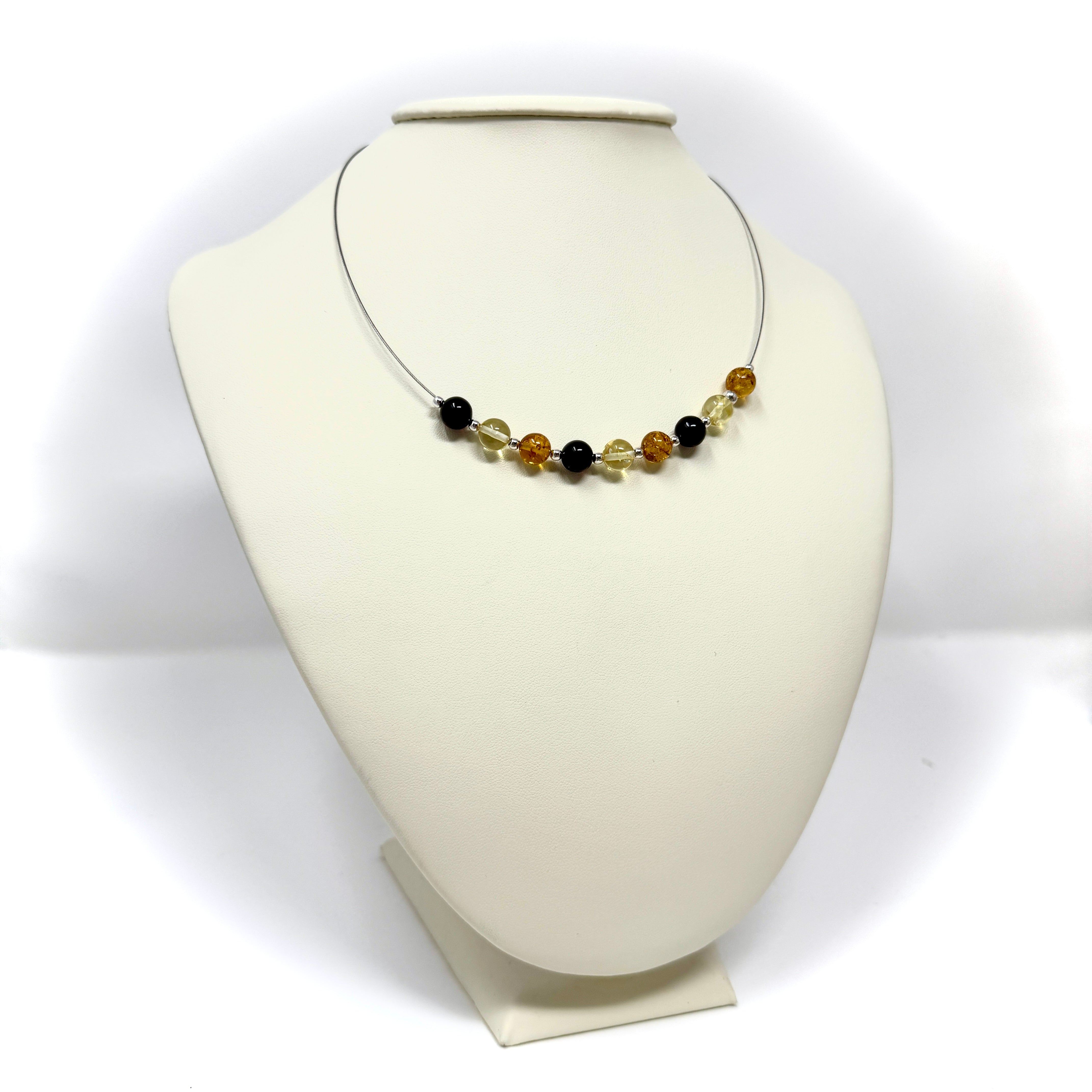 Handgefertigtes Collier aus echtem Bernstein in Honig- und Cognactönen, kombiniert mit tiefschwarzem Onyx und silbernen Akzenten. Stilvoll, elegant und einzigartig.
